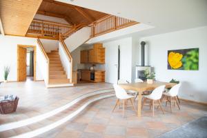 a kitchen and dining room with a wooden table and chairs at Seehof direkt am See in Seeleiten