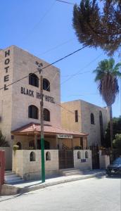 a large building with a sign on the side of it at Black Iris Hotel in Madaba