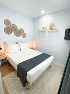 1 dormitorio con 1 cama blanca grande y TV en Villa Verde, en Madrid
