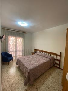 a bedroom with a bed and a blue chair at Apartaments Sant Antoni in Ribes de Freser