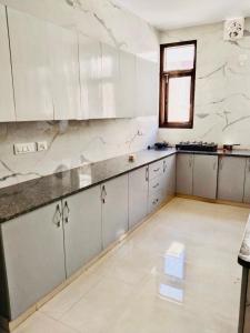 a large kitchen with white cabinets and a window at Fortune Home Service Apartment 2Bhk,E28 Saket 2A in New Delhi