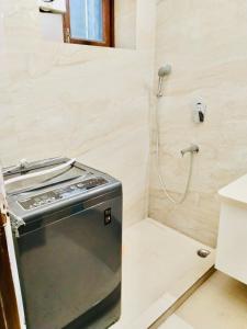 a shower in a bathroom with a stove at Fortune Home Service Apartment 2Bhk,E28 Saket 2A in New Delhi