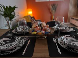 stół z talerzem jedzenia i kieliszkami do wina w obiekcie - NEW - La TerraCalm - WiFi / Netflix w mieście Cherbourg en Cotentin