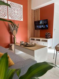 een woonkamer met oranje muren en een tafel bij - NEW - La TerraCalm - WiFi / Netflix in Cherbourg en Cotentin