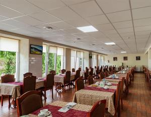 a dining room with tables and chairs in a room at Girska Tysa Health Resort in Kvasy