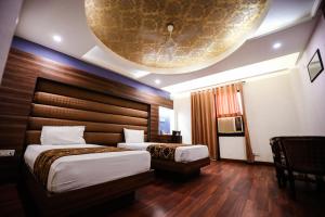 a hotel room with two beds and a large ceiling at HOMANSH GALAXY HOTEL in Kānpur +22 photos