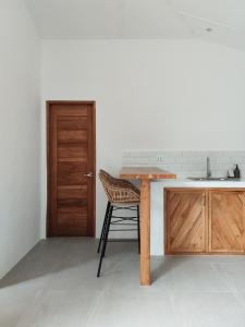 a kitchen with a wooden table and a sink at Bahala Na Villas in El Nido