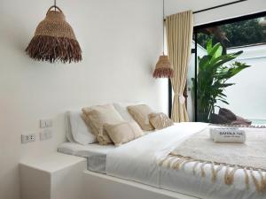 a white bed in a room with a window at Bahala Na Villas in El Nido