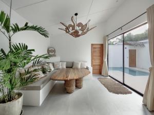 a living room with a table and potted plants at Bahala Na Villas in El Nido