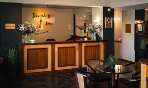 a bar in a restaurant with a table and chairs at Downhill Inn in Ballina