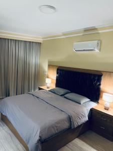 a bedroom with a large bed and two night stands with lamps at شقة مفروشة فاخرة مطلة على كورنيش النيل المعادي بالطابق 23 in Cairo