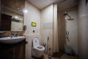a bathroom with a toilet and a sink at HOMANSH GALAXY HOTEL in Kānpur