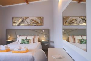 two beds in a room with two mirrors at Parrots`Village in Rabo de Peixe