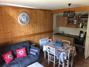 ein Wohnzimmer mit einem Sofa und einem Tisch in der Unterkunft Chalet cosy Duplex 6 personnes in Saint-Sorlin-dʼArves