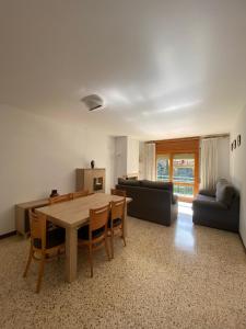 sala de estar con mesa y sofá en Apartaments Sant Antoni, en Ribes de Freser