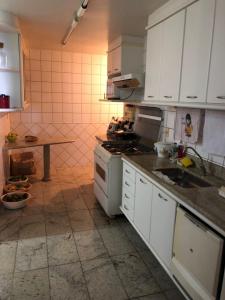 瓜拉帕里的住宿－Amplo apartamento em Guarapari com vistas pro mar，厨房配有白色橱柜和炉灶烤箱。