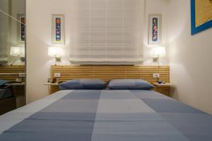 una camera da letto con un grande letto con cuscini blu di Appartamento Fico D'india a San Cataldo