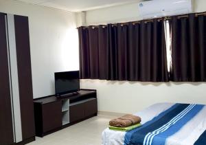 a bedroom with a bed and a flat screen tv at ห้องพักรายวัน เมืองทองธานี เรือนศรีตรัง in Ban Bang Phang