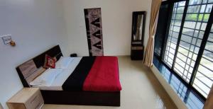 a bedroom with a bed and a large window at Kappys Villa in Igatpuri +4 photos