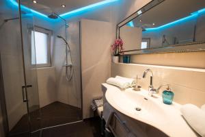 a bathroom with a sink and a shower with blue lights at PrachtBude Mayrhofen in Mayrhofen