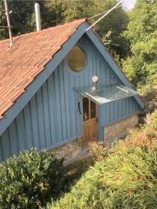 un edificio azul con ventana y puerta de madera en s'Scheunle - dein Ferienhäusle im Donautal, en Beuron