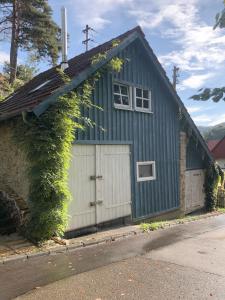 una casa azul con garaje blanco en s'Scheunle - dein Ferienhäusle im Donautal, en Beuron