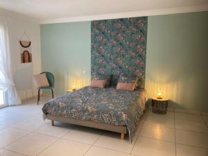 a bedroom with a large bed with a floral wallpaper at Villa avec son spa privatif proche de Rocamadour in Gramat