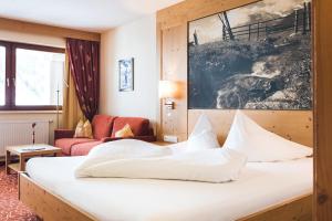 ein Hotelzimmer mit einem Bett und einem Sofa in der Unterkunft Hotel Klausnerhof in Tux