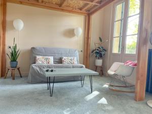 uma sala de estar com um sofá e uma mesa de centro em Oasis Fontmarie - appartement en pleine nature em Castries