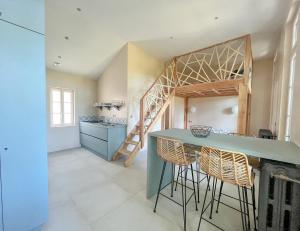 uma cozinha com um balcão e cadeiras num quarto em Oasis Fontmarie - appartement en pleine nature em Castries