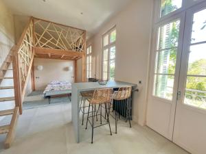 um quarto com uma mesa e um beliche em Oasis Fontmarie - appartement en pleine nature em Castries