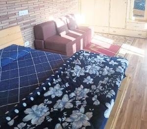 sala de estar con cama y sofá en Anuppam Home Stay, en Kulu