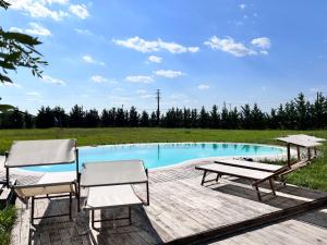 a swimming pool with two chairs and a table at Cottage indipendente con piscina privata in Masi San Giacomo