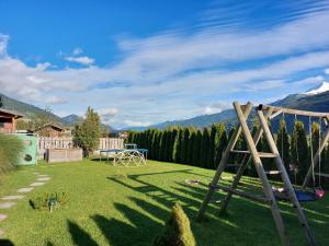 a backyard with a swing set in the grass at Apartment Lochner Piesendorf-Walchen in Piesendorf