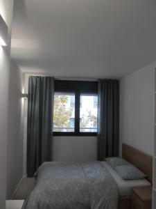 um quarto com uma cama e uma janela em Family Apartment em Vilanova i la Geltrú