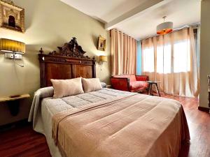 a bedroom with a large bed and a chair at Almunia de San Miguel in Toledo