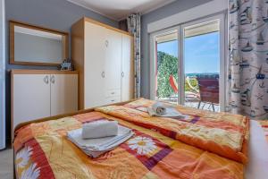 a bedroom with a bed and a large window at Apartments Milica in Crikvenica