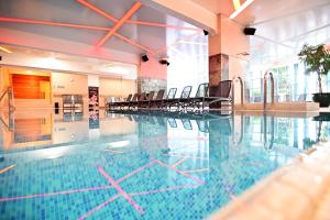 una piscina con sillas en un edificio en Hotel Eger & Park, en Eger