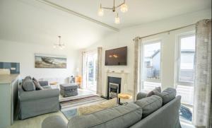 a living room with a couch and a fireplace at The Warren Holiday Park - Family Chalet in Abersoch