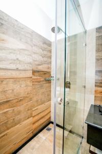 e bagno con doccia e pareti in legno. di The Zenith - A boutique hotel by Hot Millions a Mohali