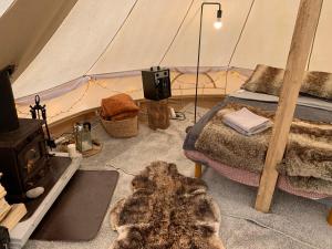 a room with a tent with a bed and a stove at Karula Stay - Exclusive Glamping Experience with Private Sauna in Ähijärve
