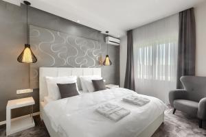 een slaapkamer met een groot wit bed en een stoel bij Villa Bella- White in Rovinjsko Selo +47 foto's