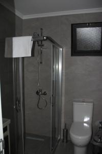 uma casa de banho com um chuveiro, um WC e um lavatório. em Okman Homes em Cirénia