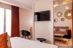 een hotelkamer met een bed en een bank bij Hotel Elysees 8 in Parijs