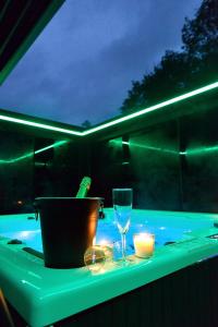 a table with a bottle of wine and a glass at SuiteDreams-Jungle Suite - Liège in Liège