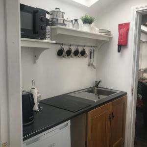 una pequeña cocina con fregadero y microondas en Serenity en Longford