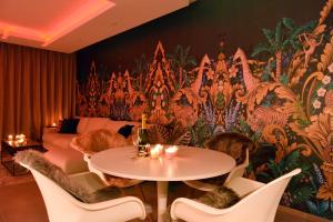 una camera con tavolo e sedie di fronte a un murale di SuiteDreams-Jungle Suite - Liège a Liegi