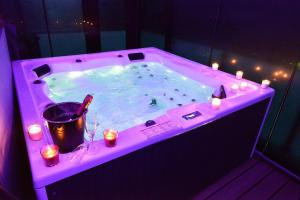 a hot tub with candles and a bottle of wine at SuiteDreams-Jungle Suite - Liège in Liège