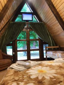 1 dormitorio con ventana, cama y TV en Бунгало en Kheivani