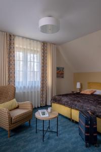 a hotel room with a bed and a couch and a table at Highland Warmia - Gospodarstwo agroturystyczne in Jeziorany